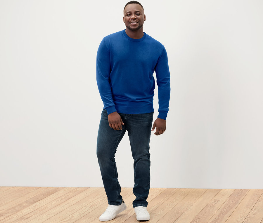 Un homme portant un pull en mérinos bleu.