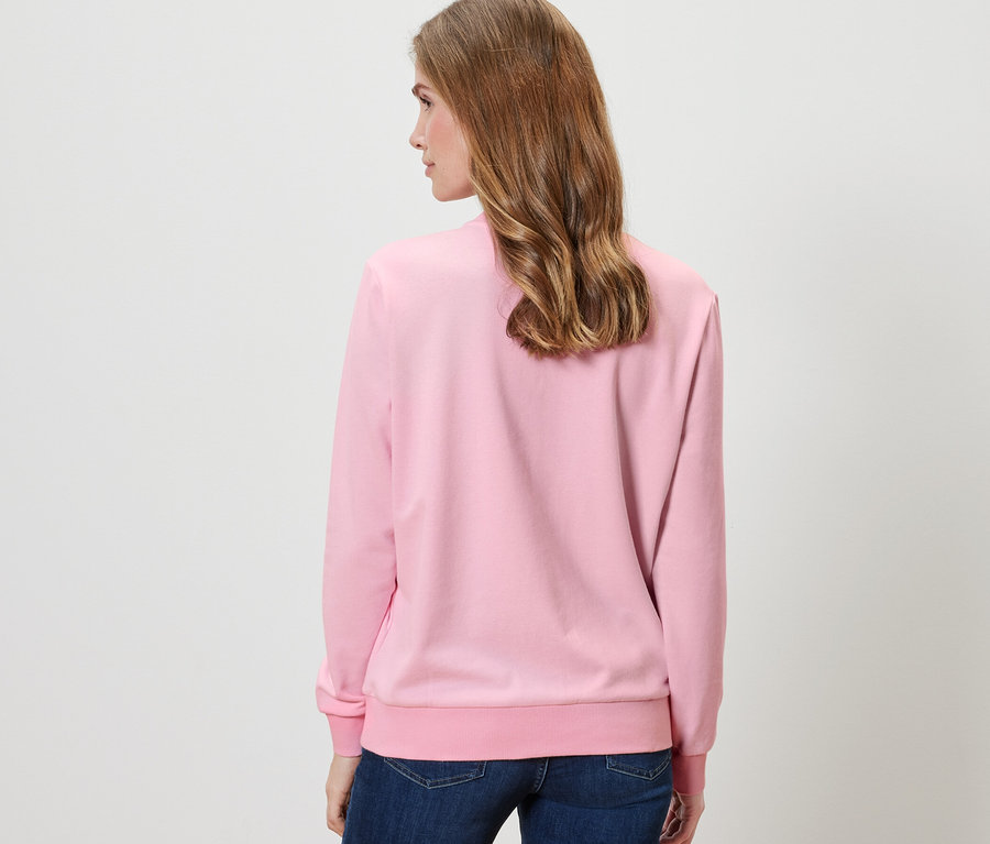 Femme vue de dos portant un sweatshirt rose.