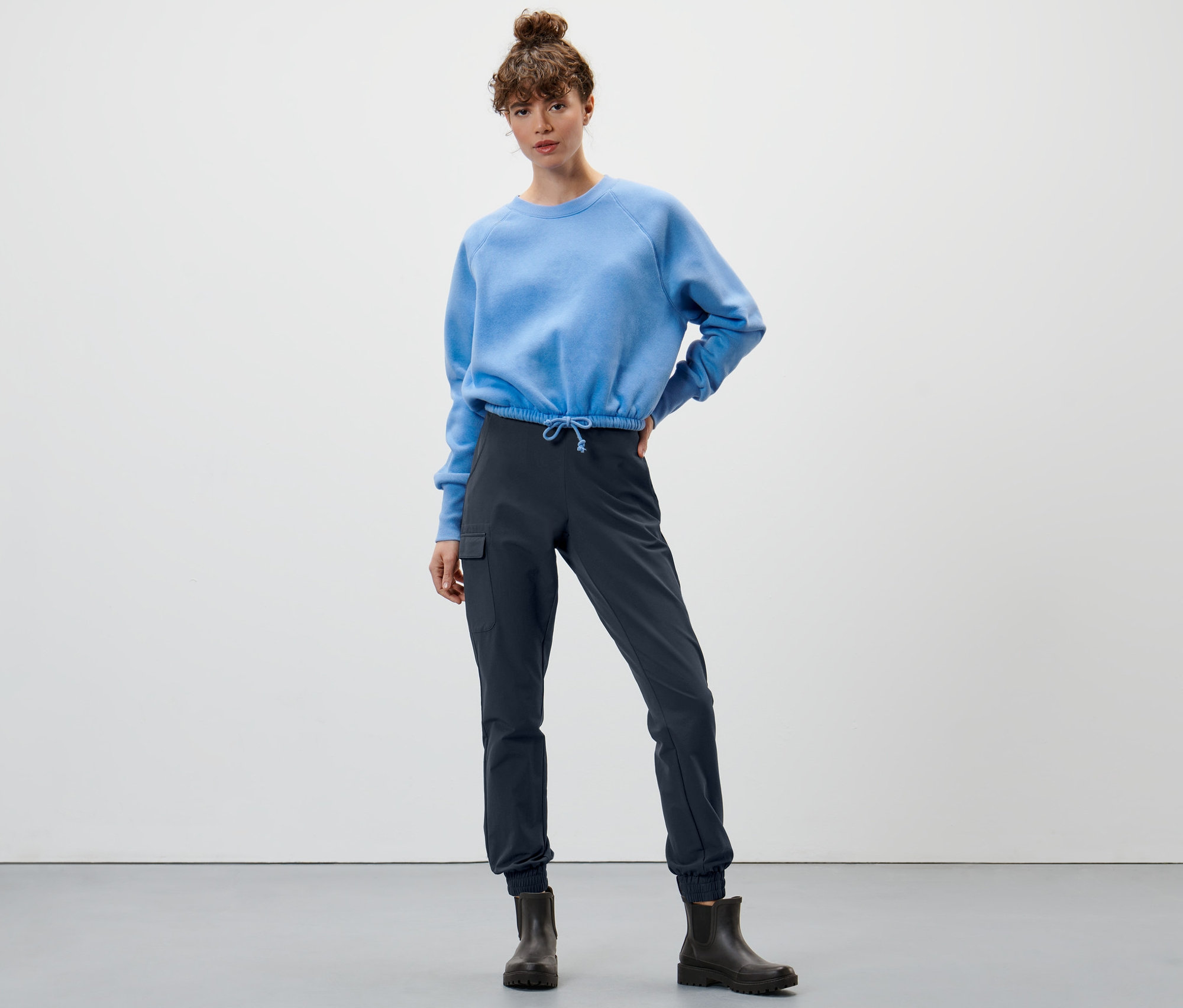 Femme posant en sweat-shirt bleu et pantalon de jogging softshell bleu marine.