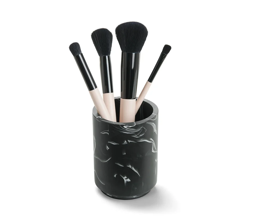 Quatre pinceaux de maquillage dans un pot finition marbrée.