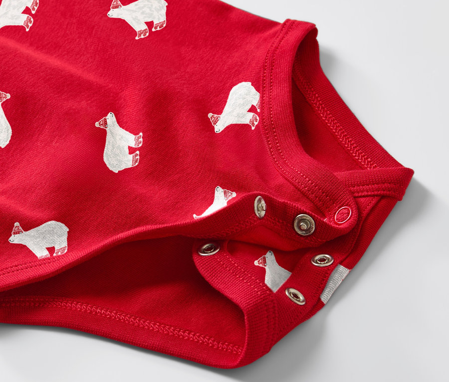 Gros plan sur un body enfant rouge à manches longues avec un imprimé d'ours polaires.