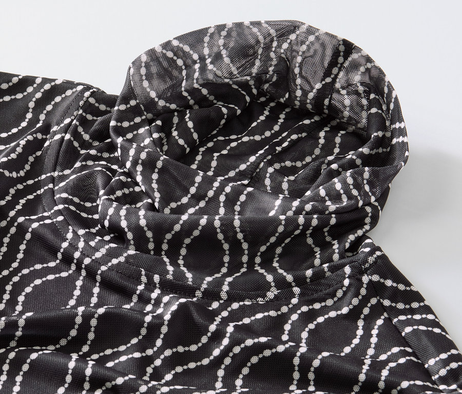 Détail d'un haut manches longues à col roulé en mesh imprimé.