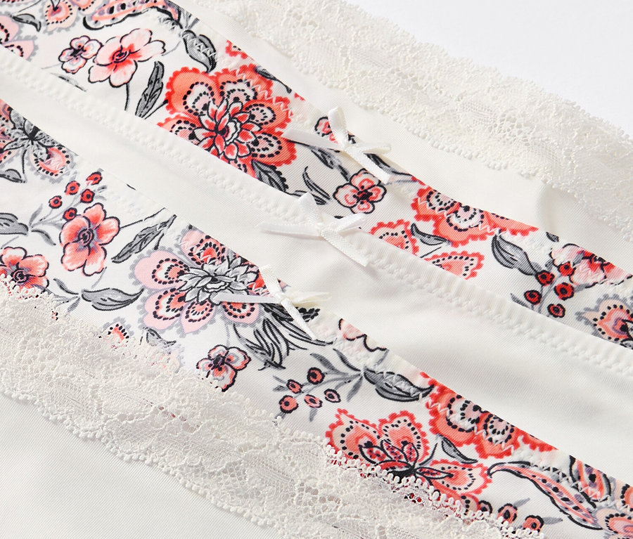 Gros plan sur 5 culottes crème à imprimé floral et dentelle.