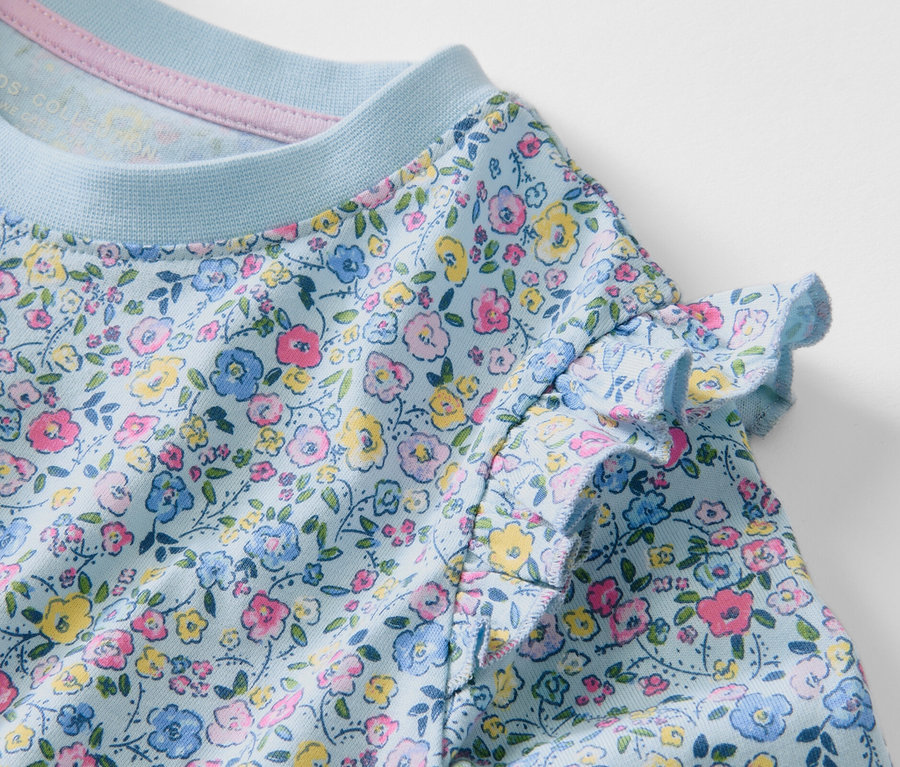 Détail d'un T-shirt à manches longues pour enfant avec un motif floral.