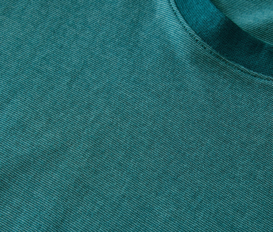Gros plan sur un ensemble pyjama shorty sarcelle, avec une texture en jersey chiné et une encolure ras du cou.