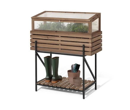 Une jardinière surélevée avec serre châssis « Elin » repose sur une étagère noire. Sur l'étagère, il y a des bottes en caoutchouc vertes et des pots de fleurs.