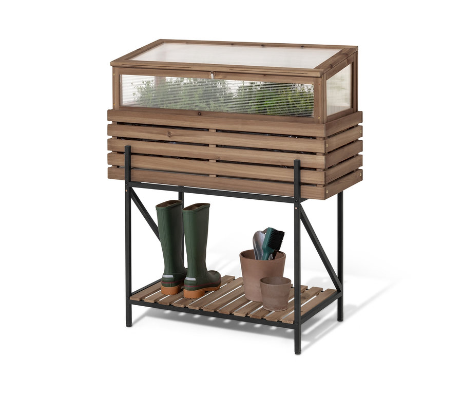 Une jardinière surélevée avec serre châssis « Elin » repose sur une étagère noire. Sur l'étagère, il y a des bottes en caoutchouc vertes et des pots de fleurs.