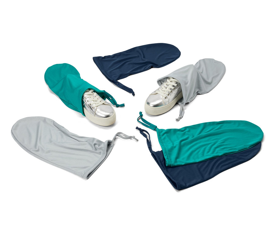 Des baskets argentées dans 6 sacs à chaussures et à linge bleus, verts et gris pour le voyage.