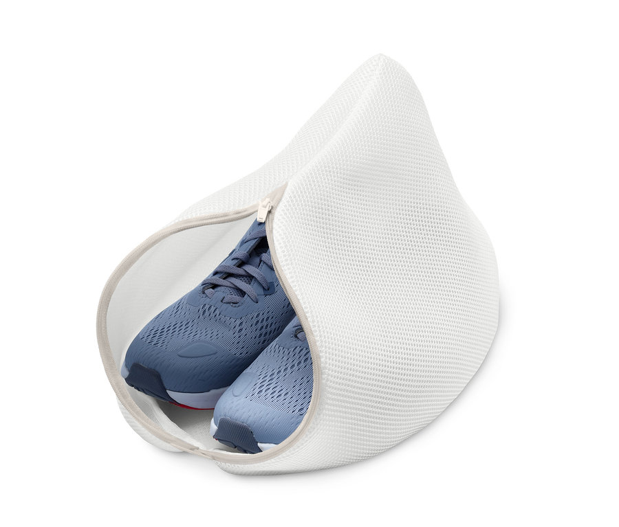 Des baskets bleues sont à l'intérieur d'un filet de lavage blanc pour chaussures.
