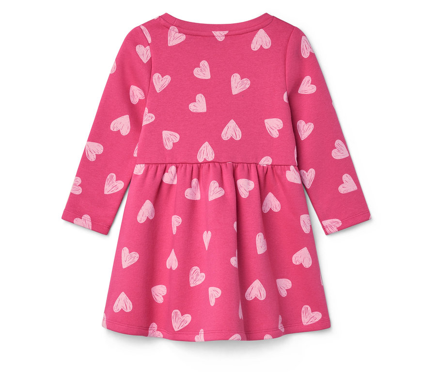 Robe rose à manches longues avec un imprimé de coeurs blancs.