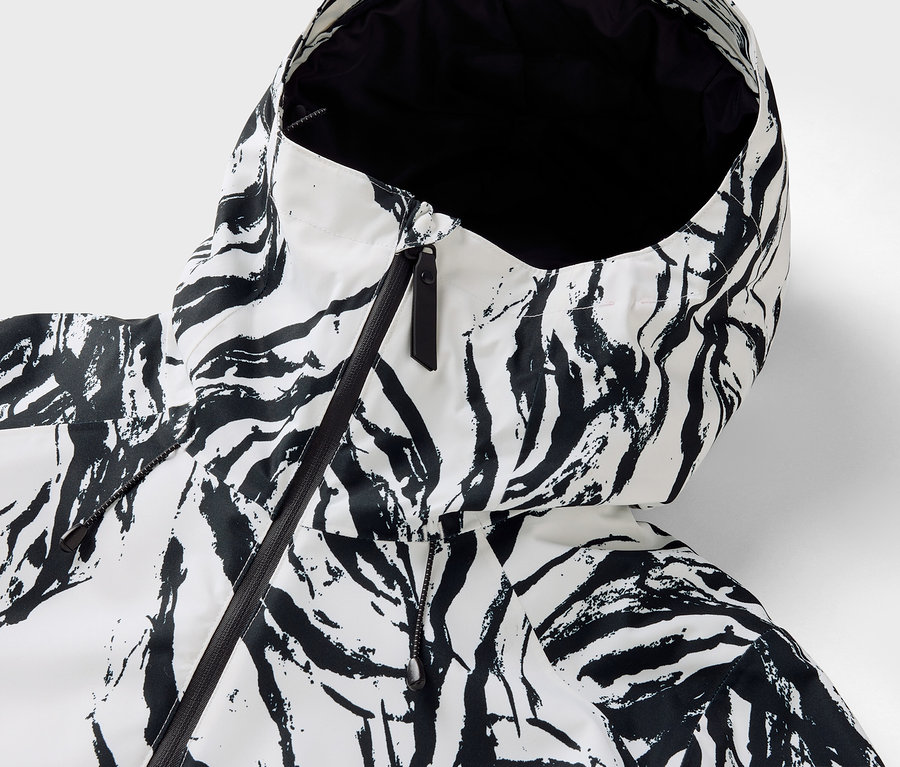 Gros plan sur la capuche d'une veste à motif zébré avec une fermeture éclair noire.