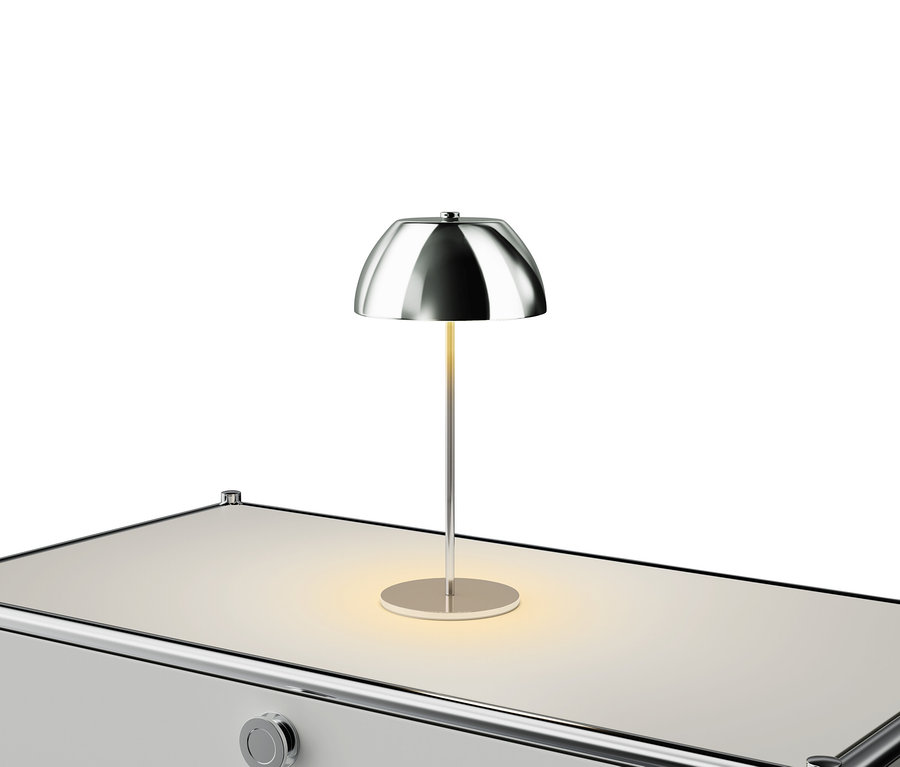 Lampe argentée sur une table blanche.