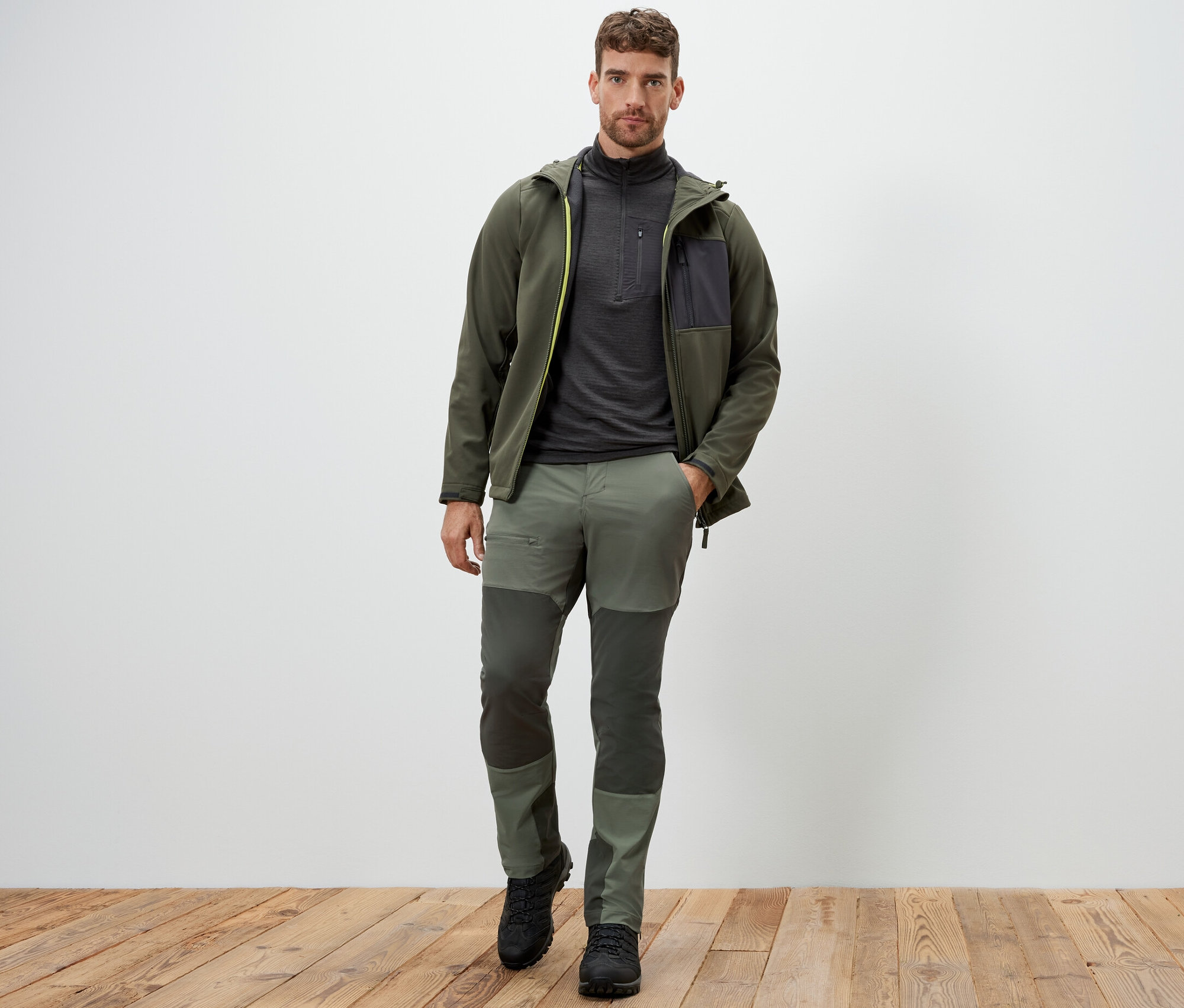 Un homme debout portant un pantalon d’extérieur vert.