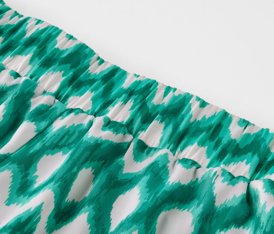 Détail d'un pantalon en satin imprimé.