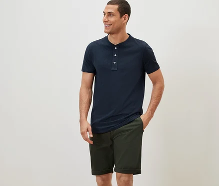 Homme portant un t-shirt bleu marine à manches courtes et un short chino kaki.