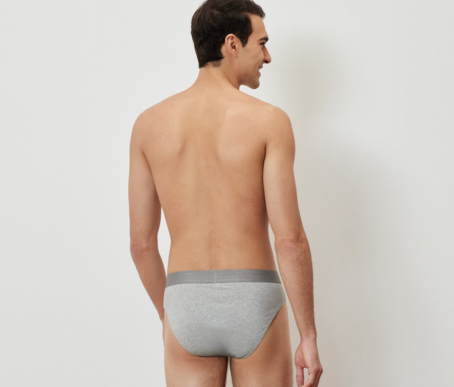 Un homme, vu de dos, porte 4 slips gris.