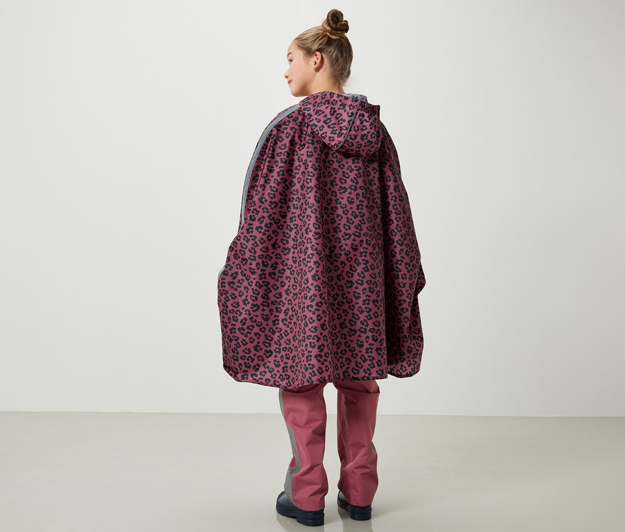 Fillette vue de dos portant un poncho de pluie rose avec imprimé.