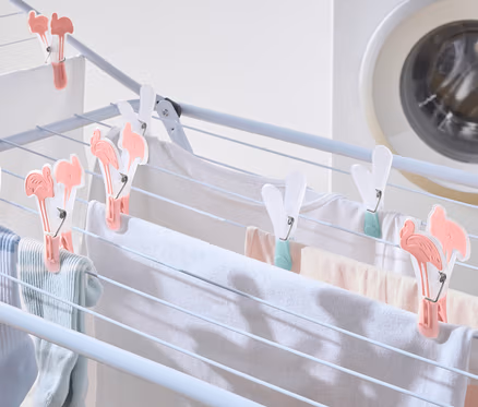 Le linge est suspendu à un séchoir et fixé par 20 pinces à linge.