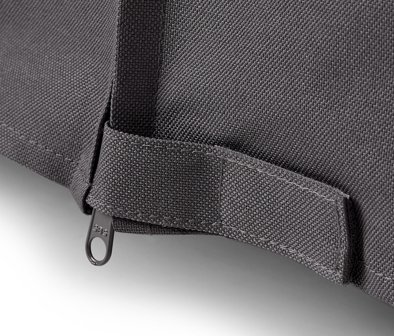 Détail d'une housse de protection premium grise pour grandes tables de jardin avec fermeture éclair.