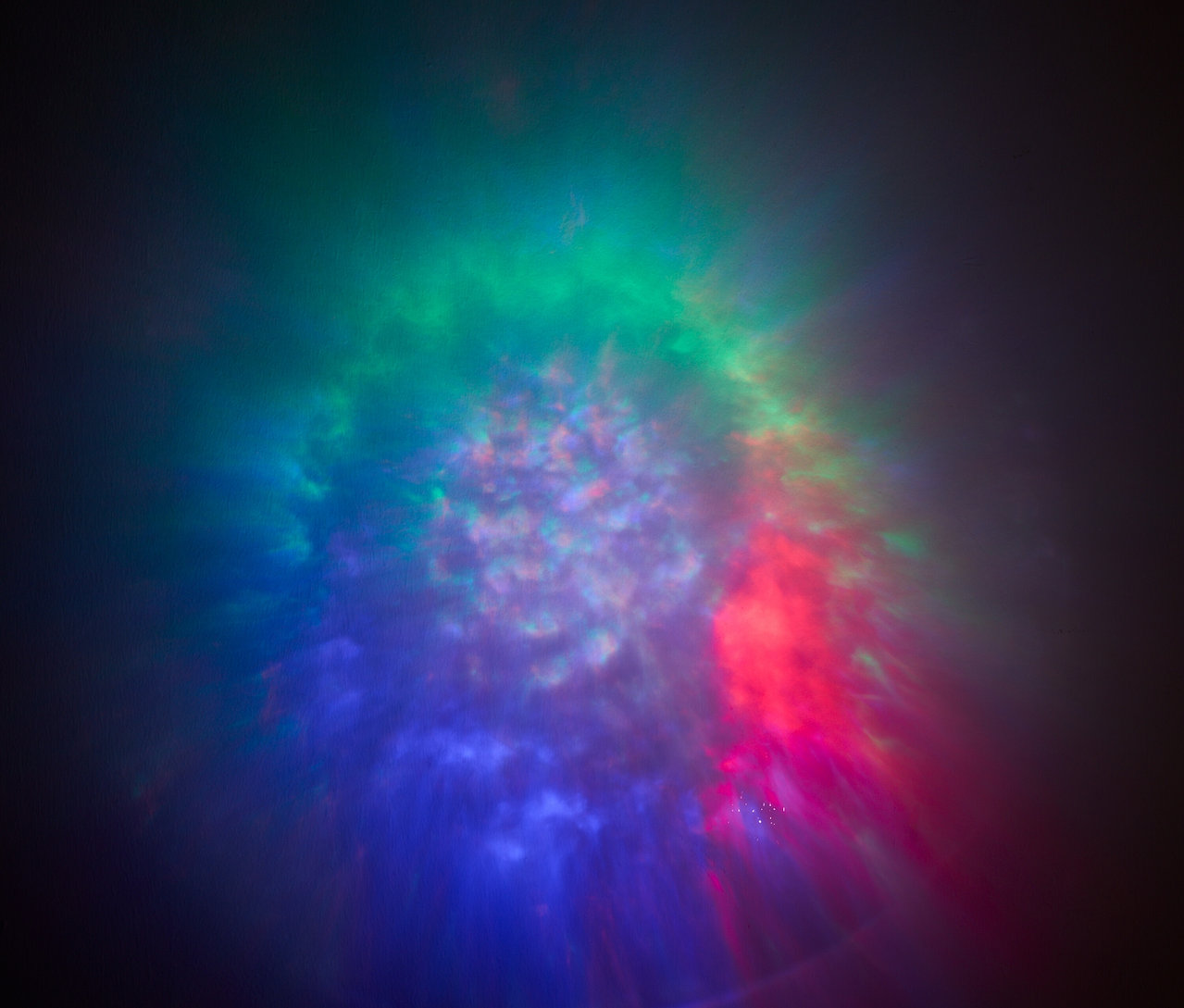 Arrière-plan abstrait avec des lumières floues dans les tons bleu, vert et rouge.