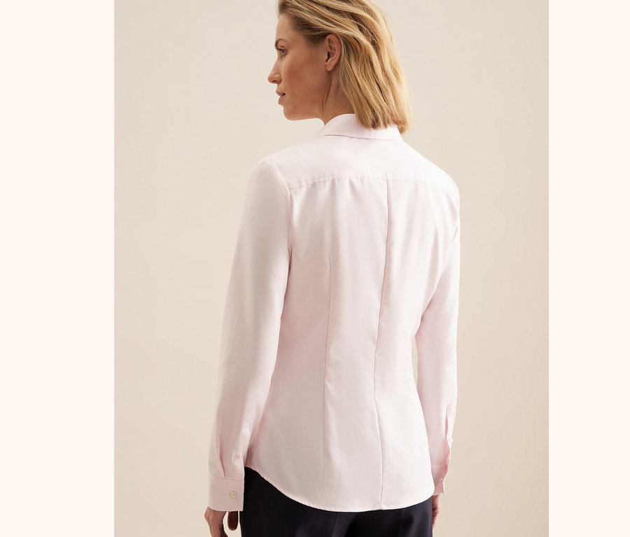 Femme portant une chemise en tulle rose Seidensticker.