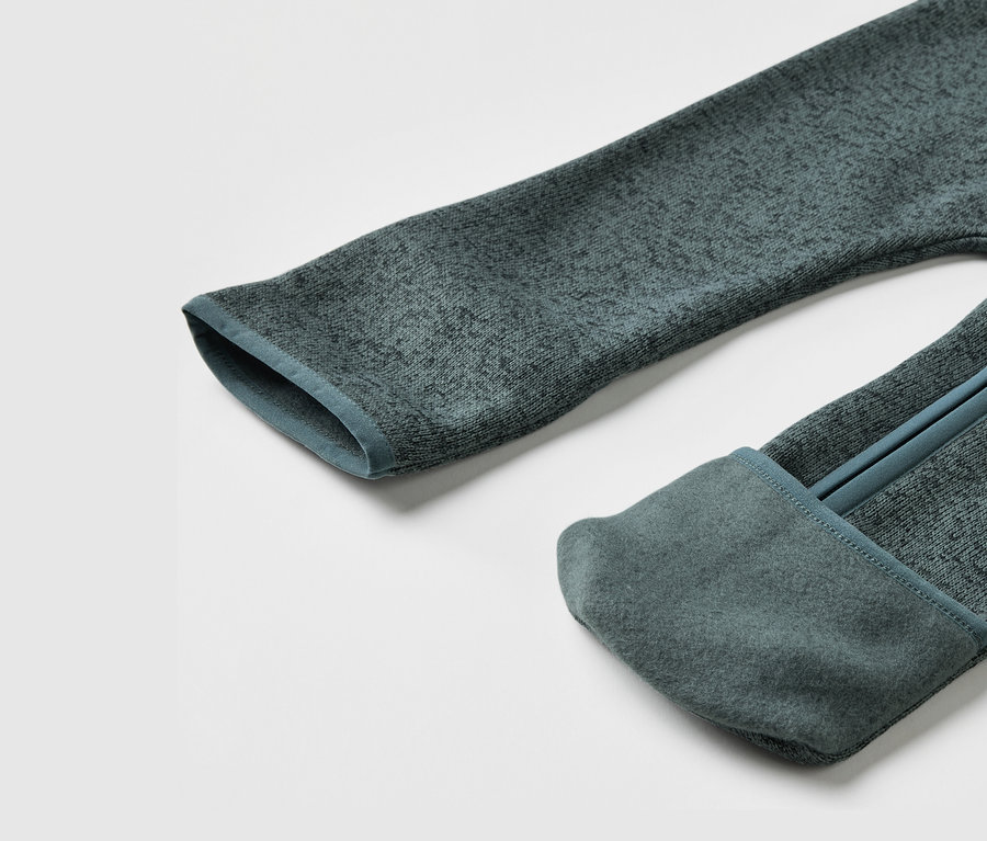 Détail d'une combinaison en polaire tricotée pour bébé.