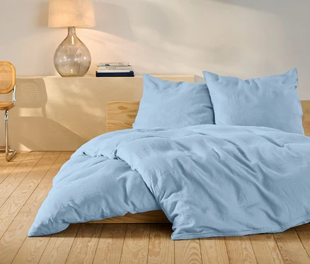 Ensemble de literie en lin bleu clair de taille standard sur un lit.