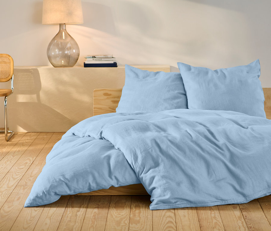 Ensemble de literie en lin bleu clair de taille standard sur un lit.