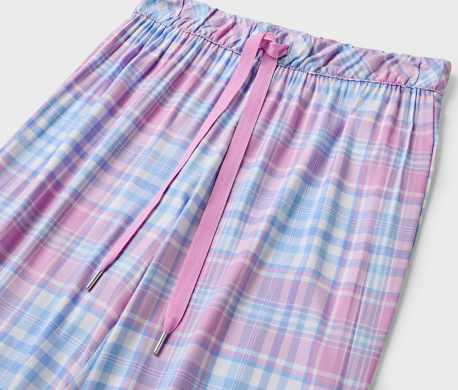 Gros plan sur un pantalon à carreaux pour femmes avec cordon de serrage rose.