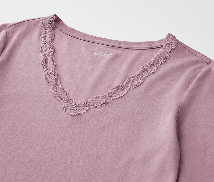 Gros plan sur un t-shirt à manches longues violet avec un décolleté en V bordé de dentelle.