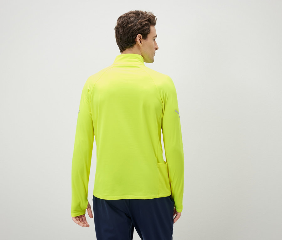 Un homme, vu de dos, porte un haut de sport jaune néon à manches longues.