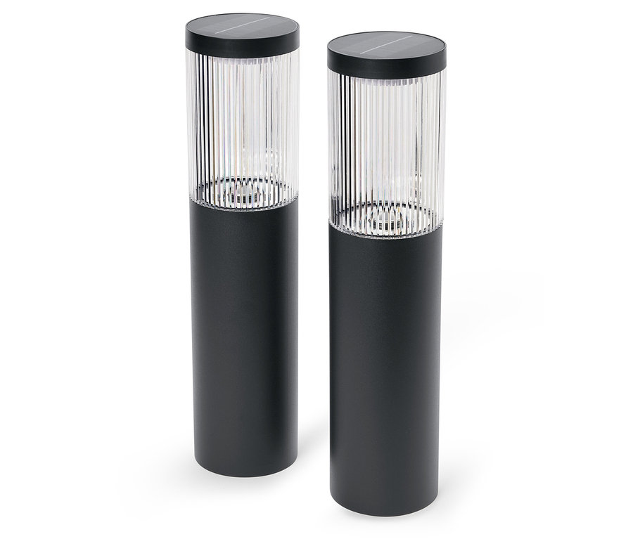 Deux lampes solaires noires sur fond blanc.