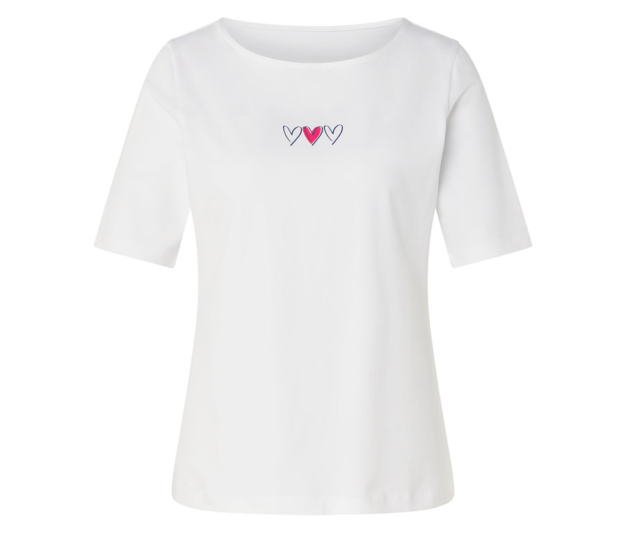 T-shirt blanc à manches courtes et col bateau, avec trois petites broderies de cœurs sur la poitrine; le cœur du milieu est rose, les extérieurs sont bordés de noir.