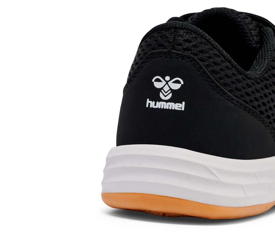 Gros plan d'une chaussure Hummel noire avec une semelle blanche et une touche de marron.