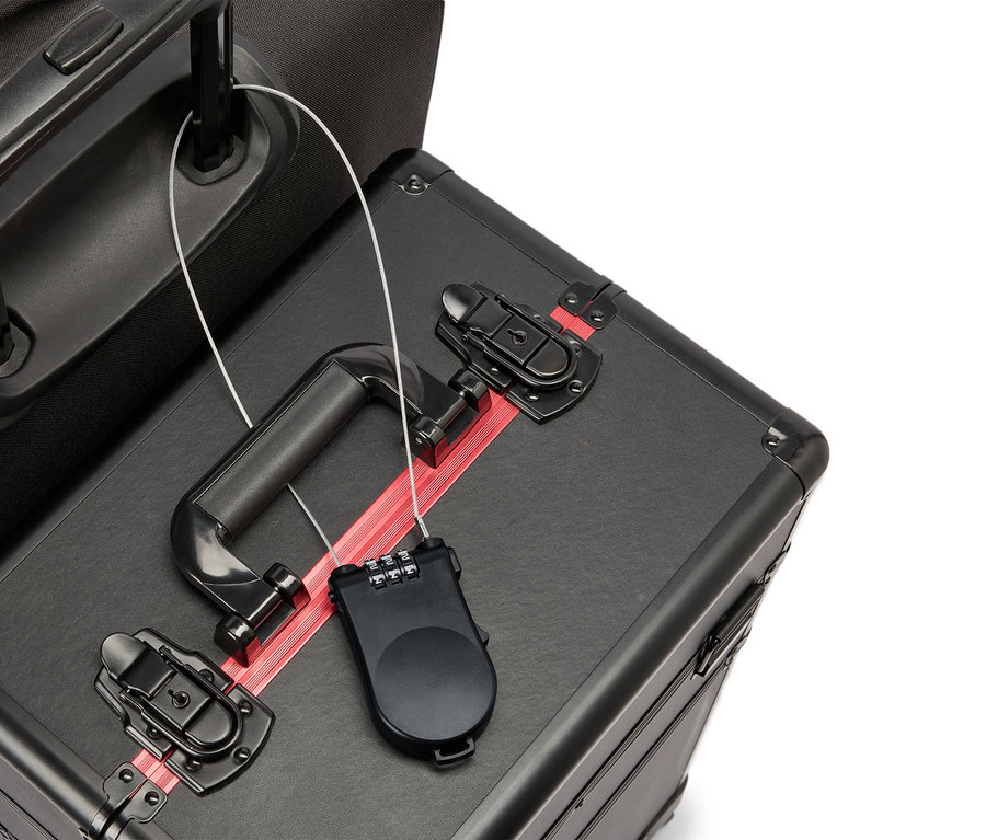 Gros plan d'une valise noire avec une bande rouge, une poignée noire et un cadenas à combinaison.