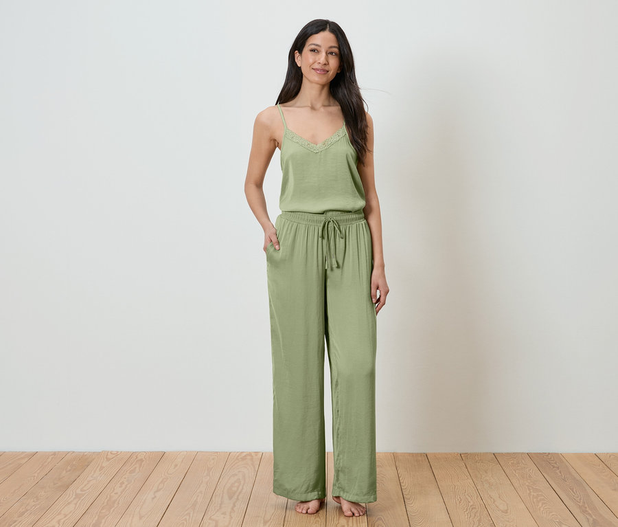 Femme debout avec la main dans la poche, portant un ensemble de détente deux pièces vert.