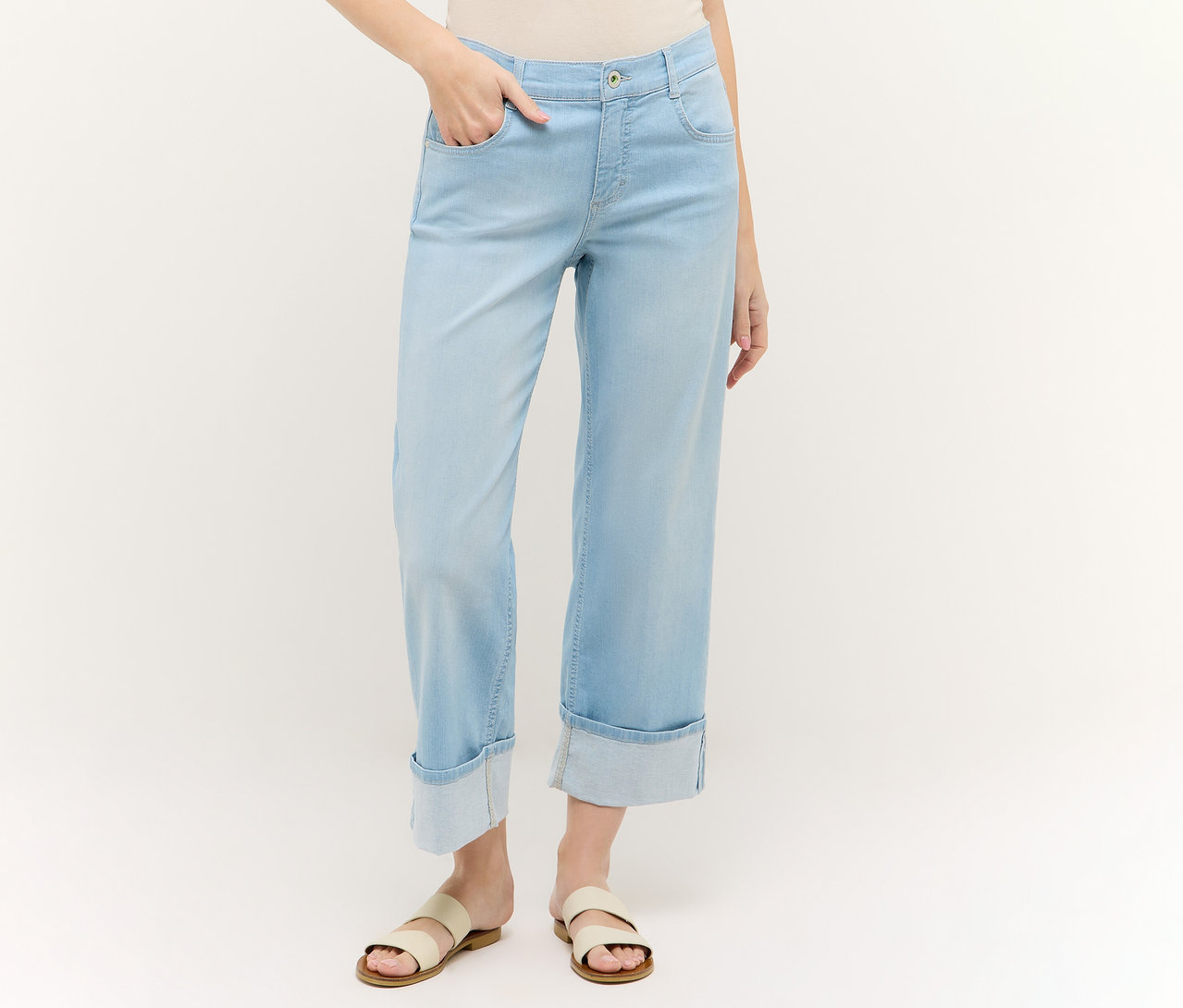 Femme portant un jean Angels Denim «
Laia Turn-Up
», Wide Leg, bleu clair et des sandales. Une main dans la poche.