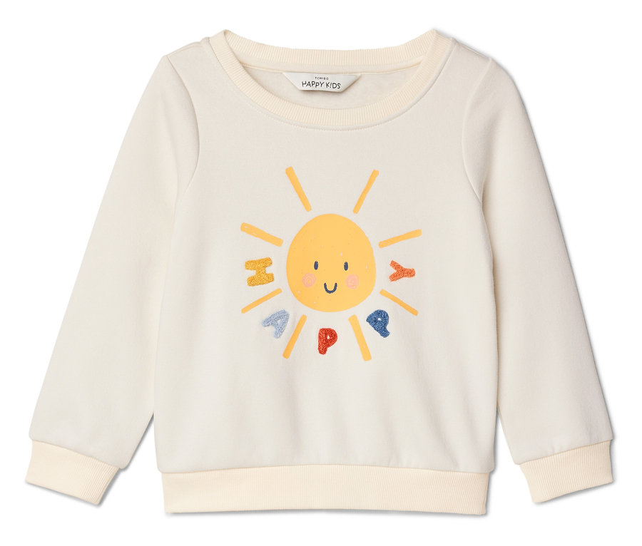 Un sweat-shirt crème avec un motif de visage de soleil jaune et le mot "HAPPY" dessus.