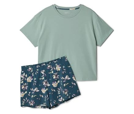 Un t-shirt vert clair est posé à côté d'un short à manches courtes bleu marine à motifs floraux.