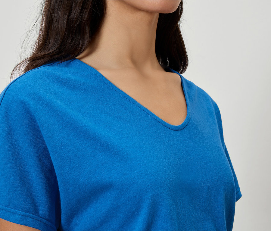 Gros plan d'une femme portant un t-shirt bleu à col en V.