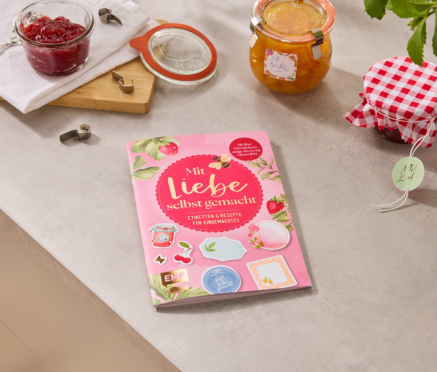 Sur un plan de travail, il y a des pots de confiture et le livre «Mit Liebe selbstgemacht».