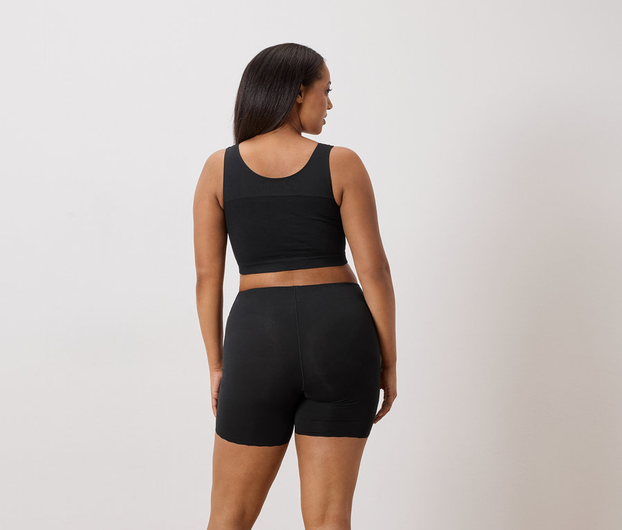 Femme vue de dos, portant un débardeur et un short noirs.