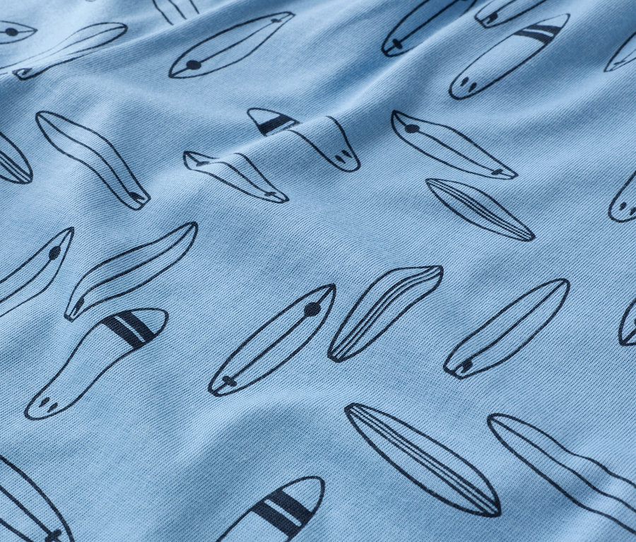 Gros plan d'un tissu bleu clair avec un motif de planches de surf noires.