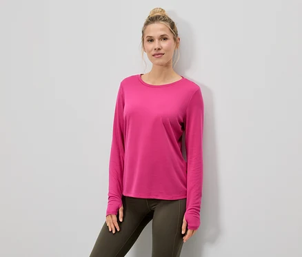 Femme portant un haut à manches longues rose et des leggings.