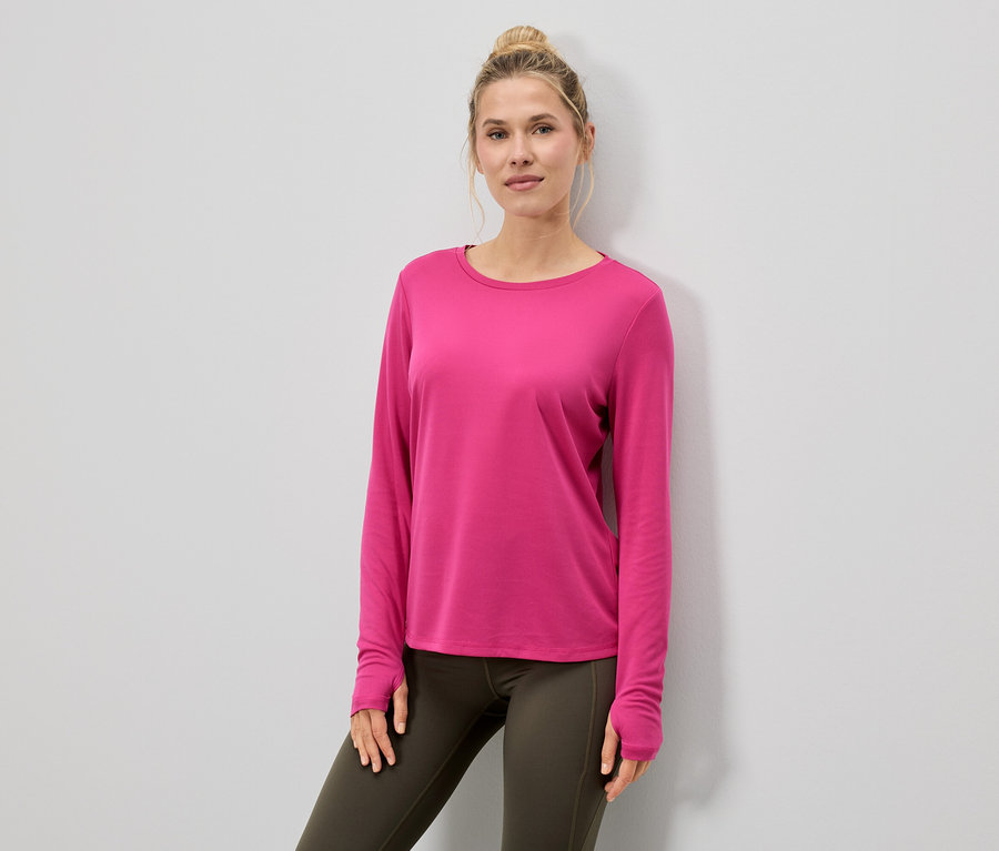 Femme portant un haut à manches longues rose et des leggings.