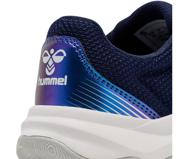 Gros plan du talon d'une chaussure en maille bleu foncé avec une semelle blanche. Le talon présente un panneau irisé bleu-violet avec un logo Hummel blanc et des rayures blanches. La semelle extérieure est grise.