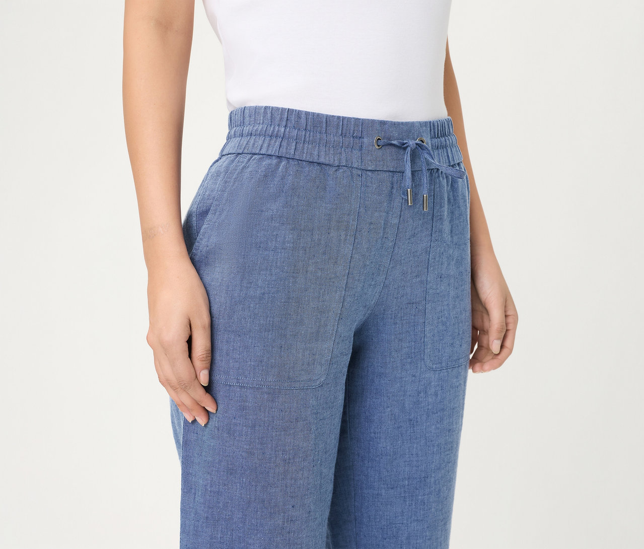 Personne portant un jean Olsen cropped bleu avec taille élastique, cordon de serrage et poches plaquées.