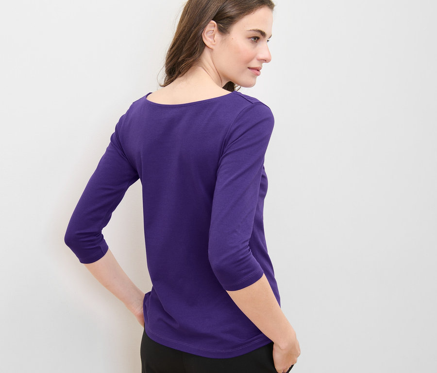 Femme posant en t-shirt violet à manches 3/4.