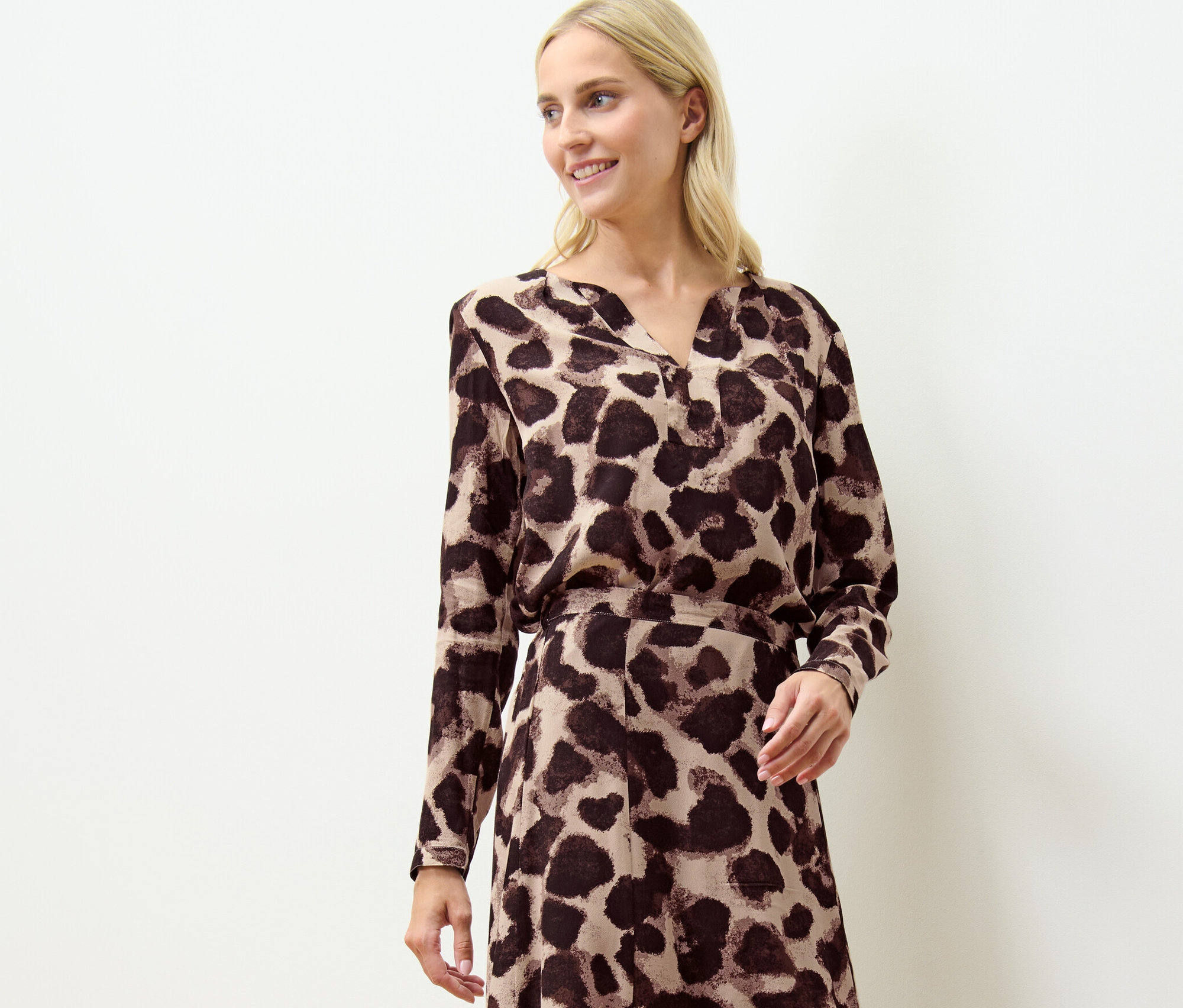 Femme blonde portant une blouse imprimée.