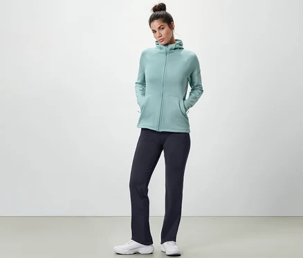 Femme posant en pantalon thermique bleu et sweat à capuche bleu clair.